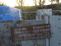 A note is asking for help with getting a modular house on the fence outside a house in Kamianka village, Kharkiv region, Ukraine, on August...