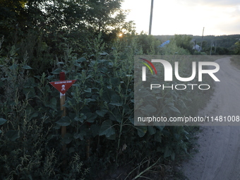 The 'Danger! Mines!' sign is standing in Kamianka village, Kharkiv region, Ukraine, on August 14, 2024, which was destroyed by Russian troop...