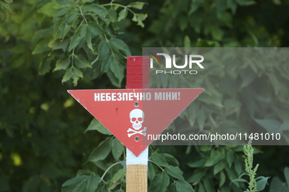 The 'Danger! Mines!' sign is standing in Kamianka village, Kharkiv region, Ukraine, on August 14, 2024, which was destroyed by Russian troop...