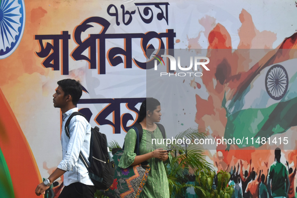 People are passing next to a mural made on the occasion of Independence Day of India in Kolkata, India, on August 15, 2024. 