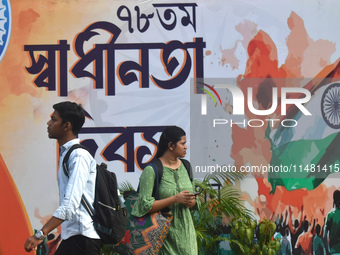 People are passing next to a mural made on the occasion of Independence Day of India in Kolkata, India, on August 15, 2024. (