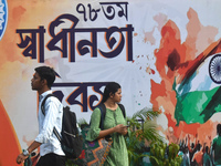 People are passing next to a mural made on the occasion of Independence Day of India in Kolkata, India, on August 15, 2024. (