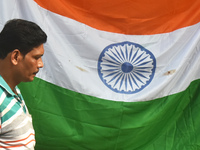 A person is passing next to the national flag of India on the occasion of Independence Day in Kolkata, India, on August 15, 2024. (