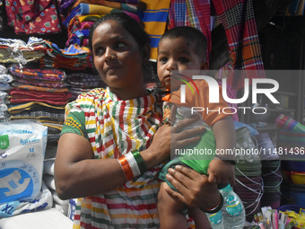 A woman is standing with her child outside of R G Kar Medical College in Kolkata, India, on August 15, 2024. (