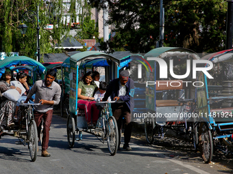 Rickshaw drivers are ferrying Indian tourists along the Mall Road in Mussoorie, Uttarakhand, India, on April 18, 2024. (