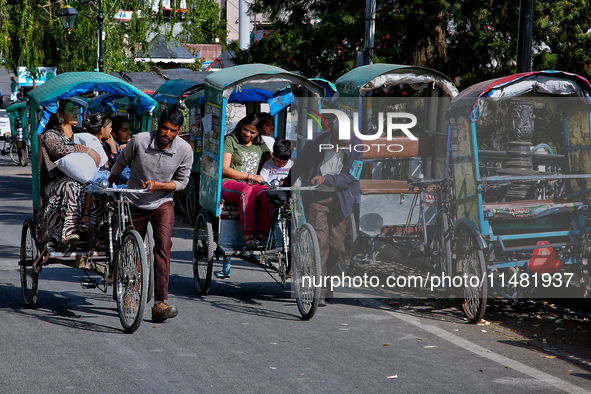 Rickshaw drivers are ferrying Indian tourists along the Mall Road in Mussoorie, Uttarakhand, India, on April 18, 2024. 