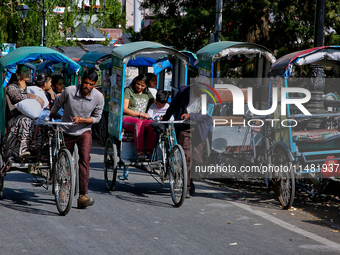 Rickshaw drivers are ferrying Indian tourists along the Mall Road in Mussoorie, Uttarakhand, India, on April 18, 2024. (