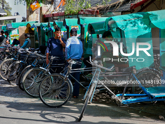 Rickshaw drivers are waiting for tourists to hire them along the Mall Road in Mussoorie, Uttarakhand, India, on April 18, 2024. (