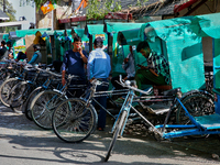 Rickshaw drivers are waiting for tourists to hire them along the Mall Road in Mussoorie, Uttarakhand, India, on April 18, 2024. (