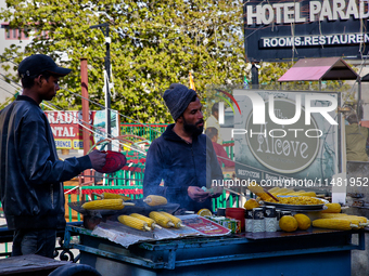 Men are grilling corn along the Mall Road in Mussoorie, Uttarakhand, India, on April 18, 2024. (