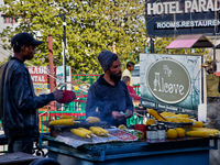 Men are grilling corn along the Mall Road in Mussoorie, Uttarakhand, India, on April 18, 2024. (