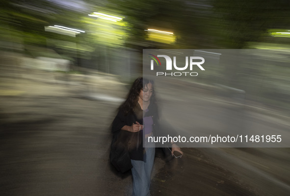 A young woman who is not wearing a mandatory headscarf is walking along a park in central Tehran, Iran, on August 15, 2024. 