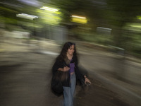 A young woman who is not wearing a mandatory headscarf is walking along a park in central Tehran, Iran, on August 15, 2024. (