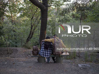 Iranian youths are sitting together at a park in central Tehran, Iran, on August 15, 2024. (