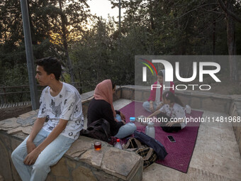 An Iranian family is camping at a park in central Tehran, Iran, on August 15, 2024. (