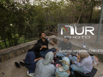 Iranian youths are celebrating a birthday while camping at a park in central Tehran, Iran, on August 15, 2024. (