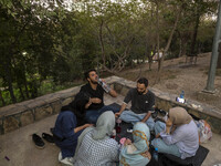 Iranian youths are celebrating a birthday while camping at a park in central Tehran, Iran, on August 15, 2024. (