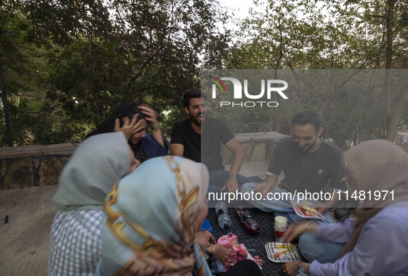 Iranian youths are celebrating a birthday while camping at a park in central Tehran, Iran, on August 15, 2024. 