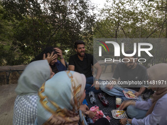 Iranian youths are celebrating a birthday while camping at a park in central Tehran, Iran, on August 15, 2024. (