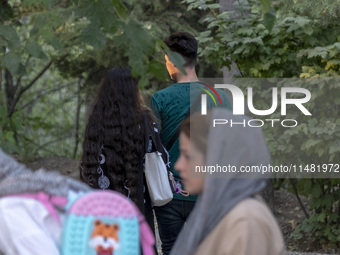 An Iranian couple is walking together along a park in central Tehran, Iran, on August 15, 2024. (