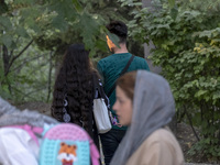 An Iranian couple is walking together along a park in central Tehran, Iran, on August 15, 2024. (