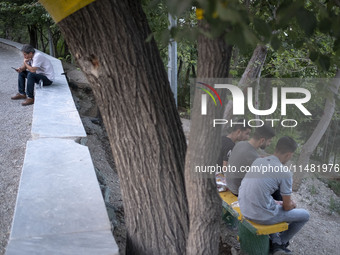 Iranian youths are sitting together at a park in central Tehran, Iran, on August 15, 2024. (