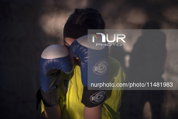 An Afghan refugee kickboxer is posing for a photograph while participating in an exercise session at a park in central Tehran, Iran, on Augu...