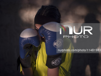 An Afghan refugee kickboxer is posing for a photograph while participating in an exercise session at a park in central Tehran, Iran, on Augu...