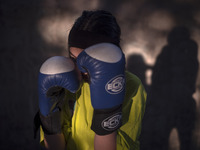 An Afghan refugee kickboxer is posing for a photograph while participating in an exercise session at a park in central Tehran, Iran, on Augu...