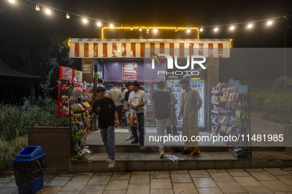 Afghan youths are standing in front of a snack stand at a park in central Tehran, Iran, on August 15, 2024. 