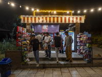 Afghan youths are standing in front of a snack stand at a park in central Tehran, Iran, on August 15, 2024. (