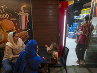 An Iranian family is sitting at an outdoor restaurant at a park in central Tehran, Iran, on August 15, 2024. (