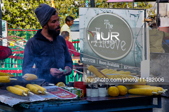 A man is selling grilled corn along the Mall Road in Mussoorie, Uttarakhand, India, on April 18, 2024. 