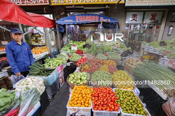 Customers are shopping at a fruit market next to Manzhouli Zhongsu Pedestrian Street in Hohhot, Inner Mongolia, China, on August 15, 2024. 