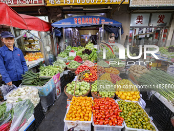 Customers are shopping at a fruit market next to Manzhouli Zhongsu Pedestrian Street in Hohhot, Inner Mongolia, China, on August 15, 2024. (