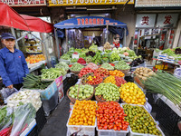 Customers are shopping at a fruit market next to Manzhouli Zhongsu Pedestrian Street in Hohhot, Inner Mongolia, China, on August 15, 2024. (