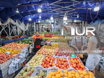 Customers are shopping at a fruit market next to Manzhouli Zhongsu Pedestrian Street in Hohhot, Inner Mongolia, China, on August 15, 2024. (