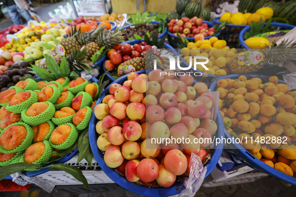 Customers are shopping at a fruit market next to Manzhouli Zhongsu Pedestrian Street in Hohhot, Inner Mongolia, China, on August 15, 2024. 