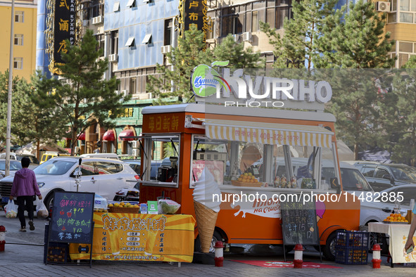 Customers are shopping at a fruit market next to Manzhouli Zhongsu Pedestrian Street in Hohhot, Inner Mongolia, China, on August 15, 2024. 