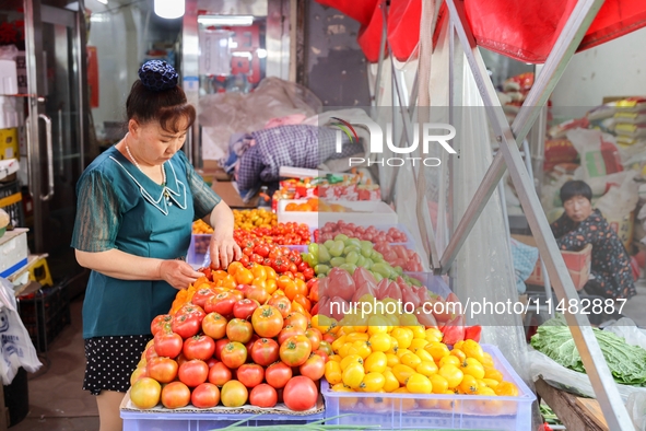 Customers are shopping at a fruit market next to Manzhouli Zhongsu Pedestrian Street in Hohhot, Inner Mongolia, China, on August 15, 2024. 