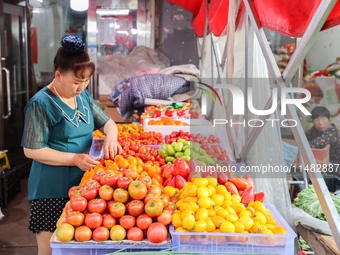 Customers are shopping at a fruit market next to Manzhouli Zhongsu Pedestrian Street in Hohhot, Inner Mongolia, China, on August 15, 2024. (