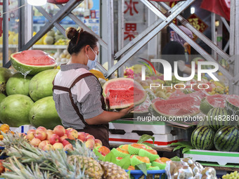 Customers are shopping at a fruit market next to Manzhouli Zhongsu Pedestrian Street in Hohhot, Inner Mongolia, China, on August 15, 2024. (