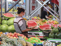 Customers are shopping at a fruit market next to Manzhouli Zhongsu Pedestrian Street in Hohhot, Inner Mongolia, China, on August 15, 2024. (