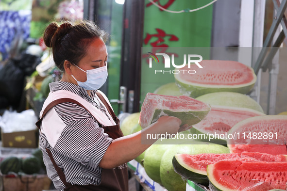 Customers are shopping at a fruit market next to Manzhouli Zhongsu Pedestrian Street in Hohhot, Inner Mongolia, China, on August 15, 2024. 