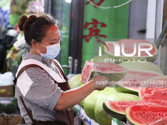 Customers are shopping at a fruit market next to Manzhouli Zhongsu Pedestrian Street in Hohhot, Inner Mongolia, China, on August 15, 2024. (