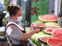 Customers are shopping at a fruit market next to Manzhouli Zhongsu Pedestrian Street in Hohhot, Inner Mongolia, China, on August 15, 2024. (