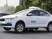 A firefighting robot is spraying water under the chassis of an electric vehicle that is simulated to be on fire and is lifting the vehicle t...