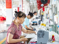 Workers are working on a production line at a workshop of a textile company in Nantong, Jiangsu province, China, on August 15, 2024. (