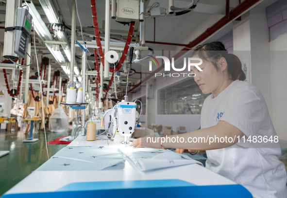 A worker is working on a production line at a workshop of a textile company in Nantong, China, on August 15, 2024. 