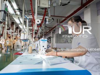 A worker is working on a production line at a workshop of a textile company in Nantong, China, on August 15, 2024. (